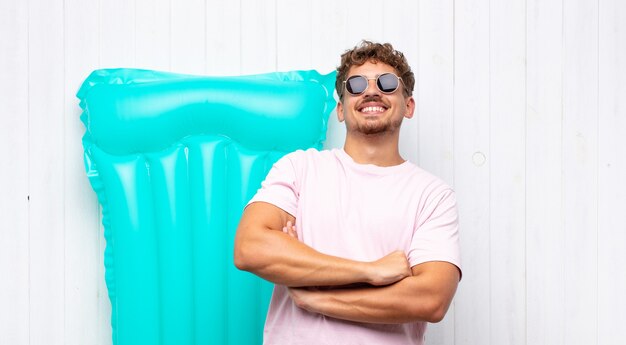 Joven riendo alegremente con los brazos cruzados, con una pose relajada, positiva y satisfecha. concepto de vacaciones