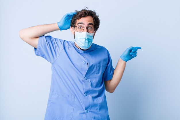 Joven riendo, feliz, positivo y sorprendido, dándose cuenta de una gran idea apuntando al espacio de copia lateral. concepto de coronavirus