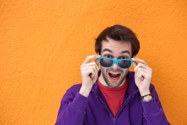 Foto joven riendo y sosteniendo gafas de sol