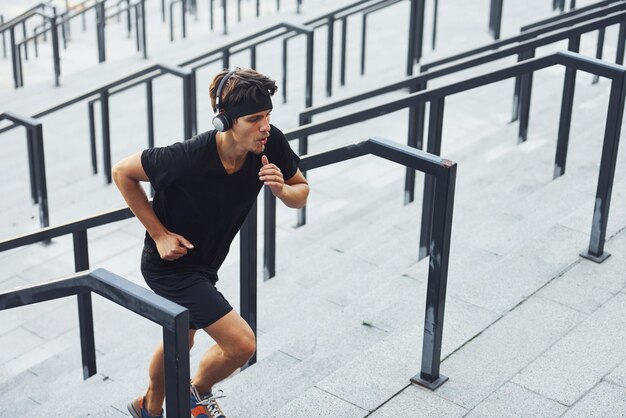 Joven con ropa deportiva hace ejercicio al aire libre durante el día