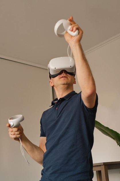 Joven con ropa informal juega juegos virtuales en casa Hombre en realidad virtual falta de movimiento