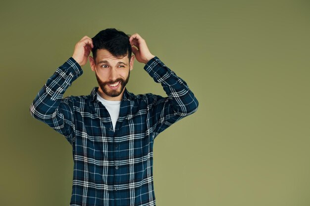 Joven con ropa informal parado en el interior del estudio