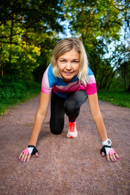 Joven rubia al inicio antes de correr en el parque el día de verano