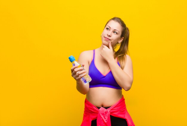 Joven rubia con una botella de agua. concepto deportivo