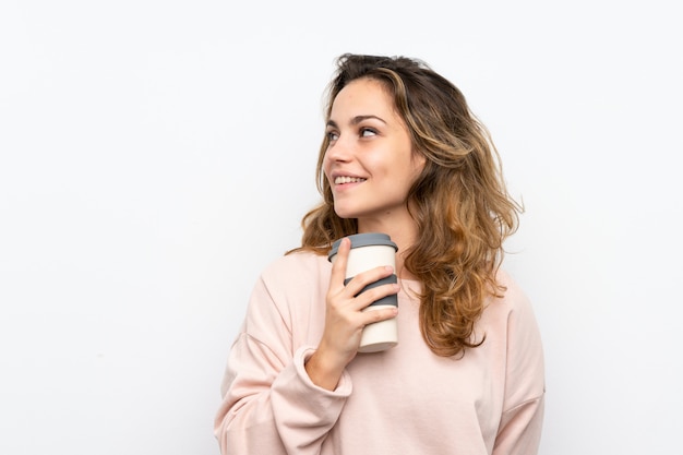 Joven rubia con café para llevar