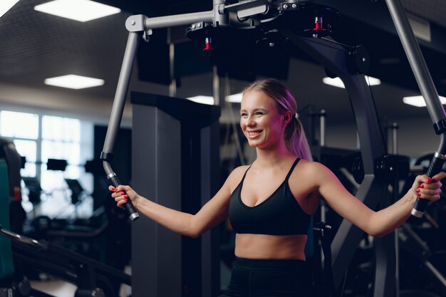 Joven rubia caucásica entrenamiento manos en un gimnasio