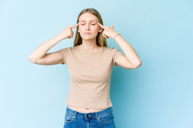 Joven rubia se centró en una tarea, manteniendo los dedos índices apuntando con la cabeza.