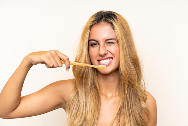 Foto joven rubia cepillando sus dientes