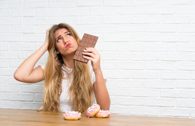 Joven rubia con chocolat teniendo dudas