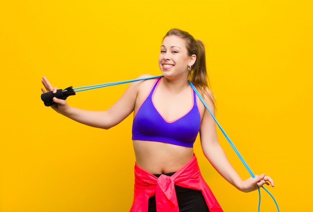 Joven rubia con una comba. concepto deportivo