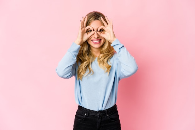 Joven rubia cubriendo las orejas con las manos