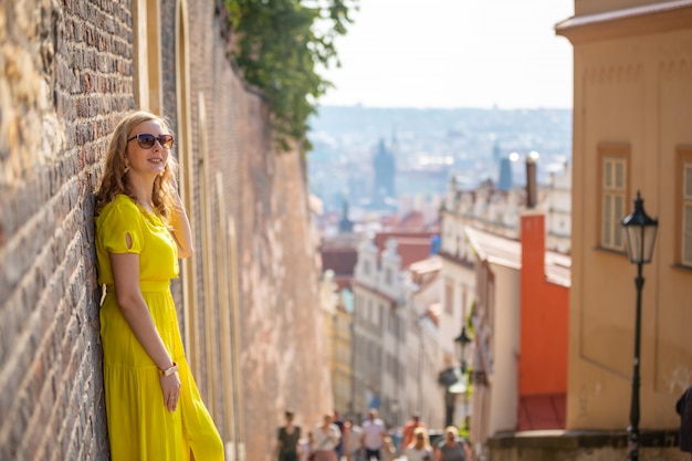 Joven rubia explorando el casco antiguo de Praga en un día soleado, República Checa