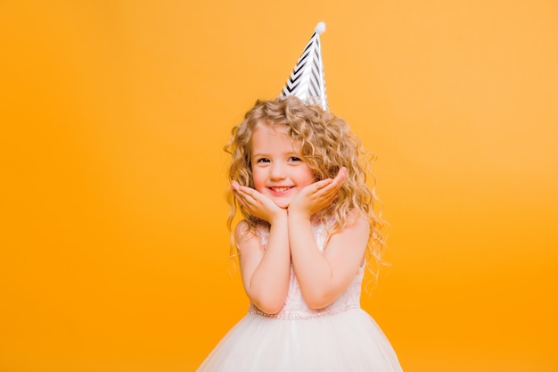 Joven rubia en fiesta de cumpleaños princesa sombrero manos repartidas gritando