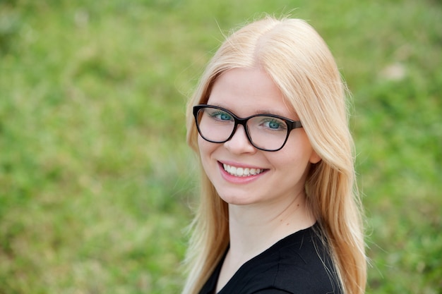 Joven rubia con gafas sonriendo