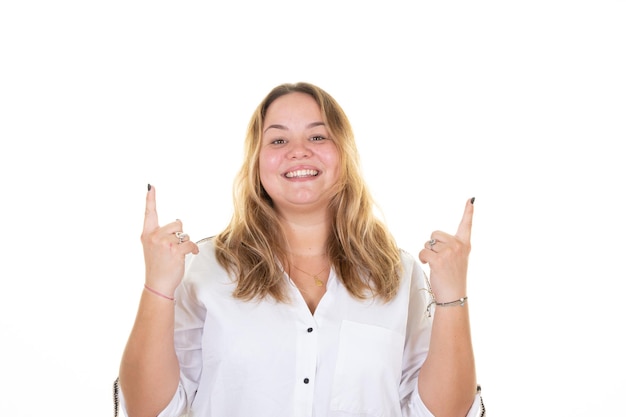 Foto joven rubia gordita sobre fondo blanco símbolo de progreso con los dedos hacia arriba sonriendo alegre mostrando las manos firmar