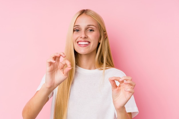 Joven rubia limpiando sus dientes con un hilo dental