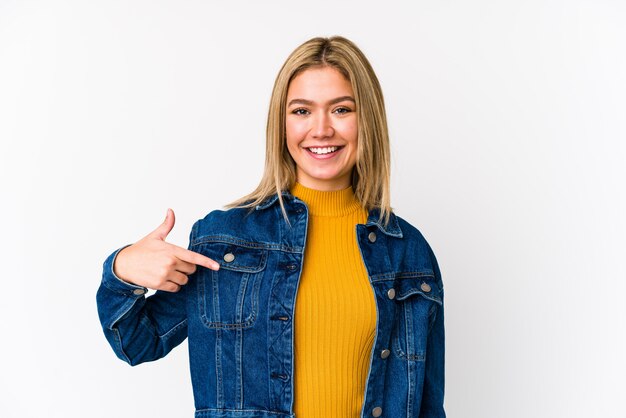 Joven rubia mujer caucásica persona aislada apuntando con la mano a una camisa copia espacio, orgulloso y confiado