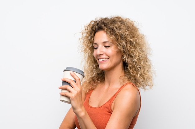 Joven rubia con el pelo rizado sosteniendo un café para llevar