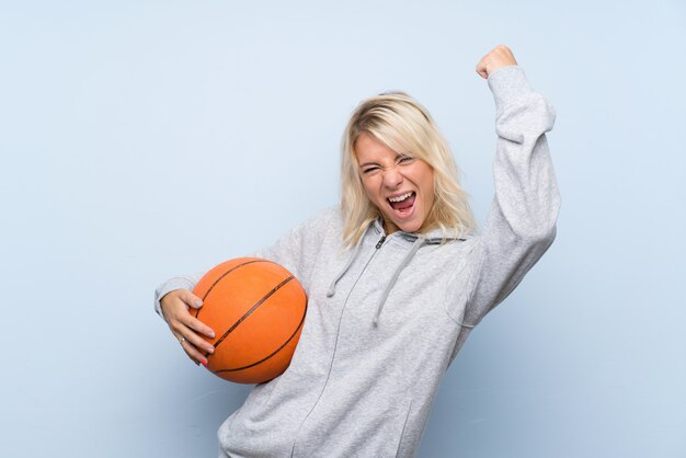 Joven rubia con pelota de baloncesto