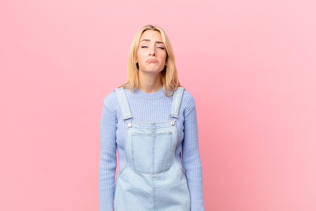 joven rubia que se siente triste y quejumbrosa con una mirada infeliz y llorando