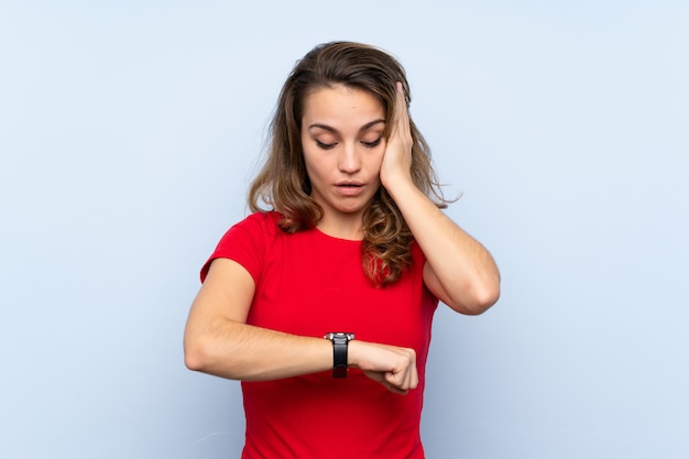 Joven rubia con reloj de pulsera y sorprendido