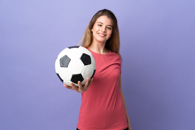 Joven rubia sobre aislado con balón de fútbol