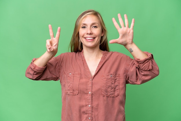 Foto joven rubia sobre un fondo aislado contando siete con los dedos