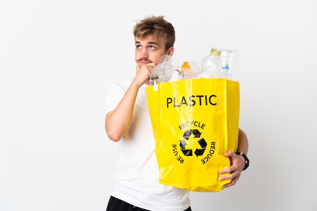 Joven rubia sosteniendo una bolsa de reciclaje llena de papel para reciclar aislado
