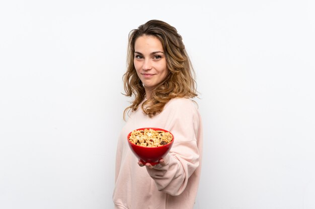 Joven rubia sosteniendo un tazón de cereales