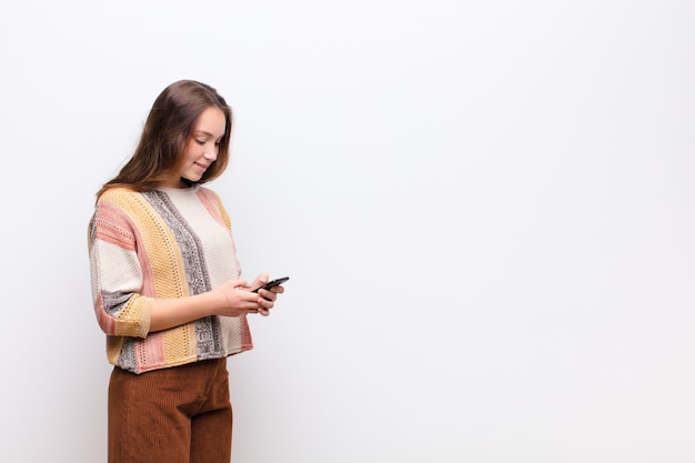 Joven rubia sosteniendo un teléfono inteligente