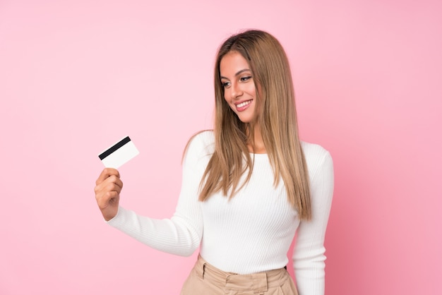 Joven rubia con una tarjeta de crédito