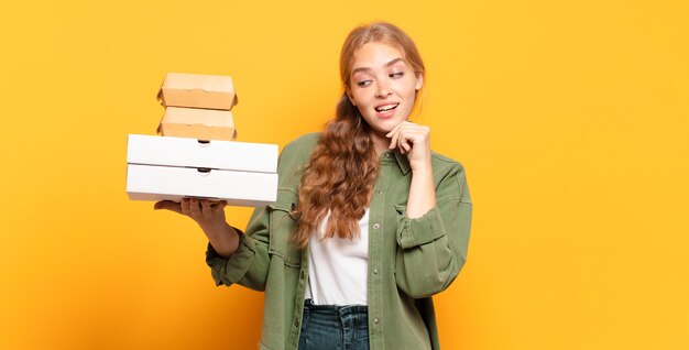 Joven rubia tomando comida rápida