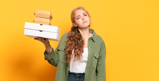 Joven rubia tomando comida rápida