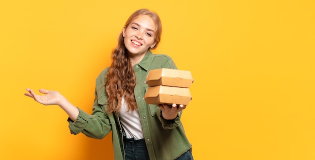 Joven rubia tomando comida rápida