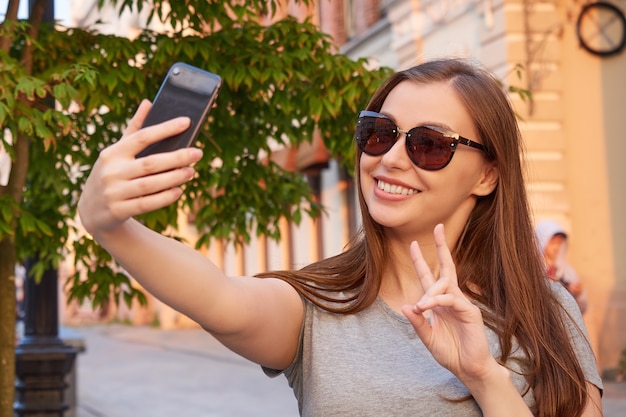 Foto joven rubia tomando un selfie