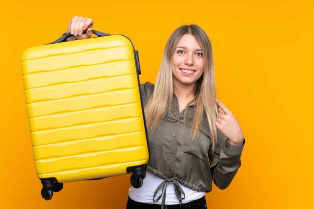 Foto joven rubia en vacaciones con maleta de viaje