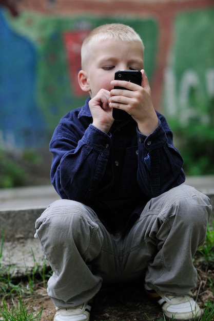 joven rubio jugando videojuegos al aire libre en el parque