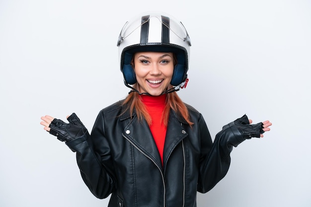 Joven rusa con un casco de motocicleta aislado de fondo blanco con una expresión facial conmocionada