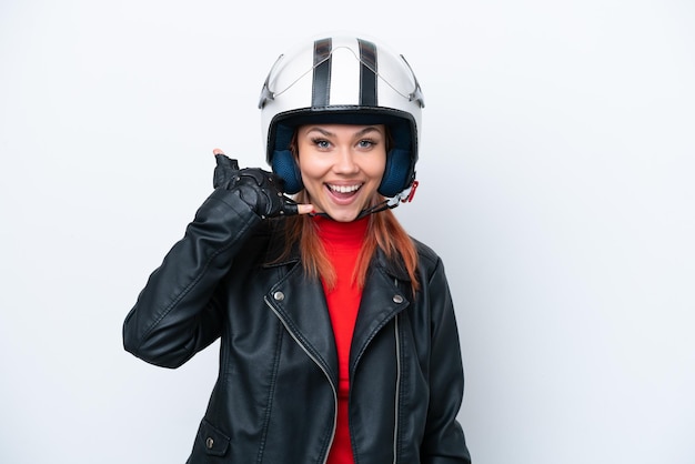 Joven rusa con un casco de motocicleta aislado en un fondo blanco haciendo un gesto telefónico Llámame de nuevo