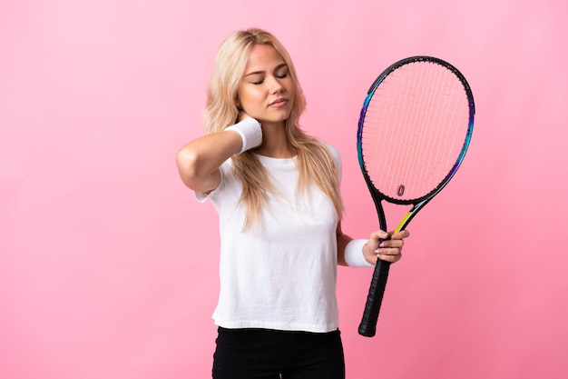 Joven rusa jugando tenis aislado en morado con dolor de cuello