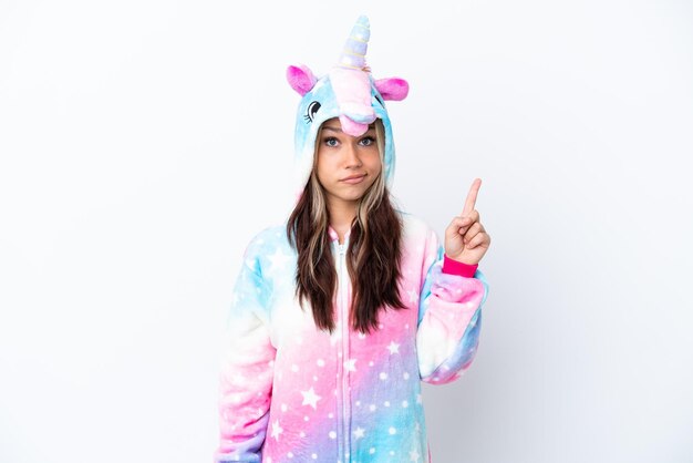 Una joven rusa con un pijama de unicornio aislada de fondo blanco señalando con el dedo índice una gran idea