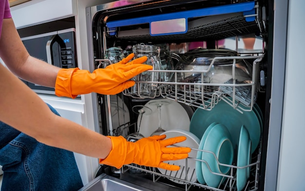 Una joven saca los platos del lavavajillas