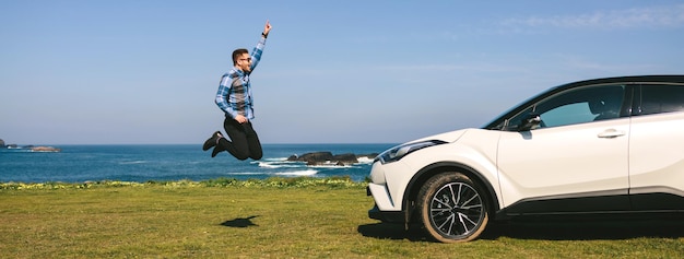 Joven saltando feliz con coche