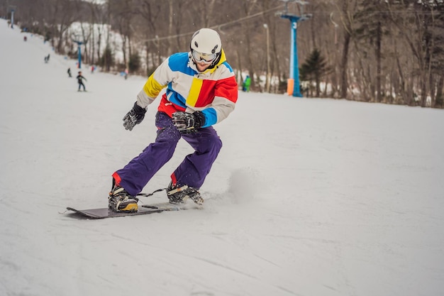 Joven saltando con una tabla de snowboard en las montañas