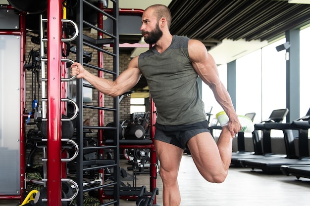 Joven saludable se estira en un gimnasio