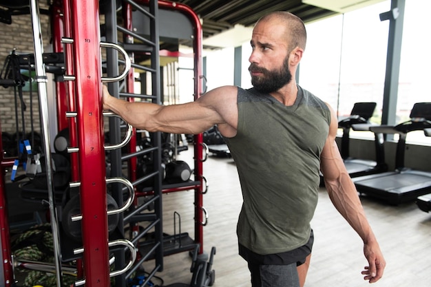 Joven saludable se estira en un gimnasio