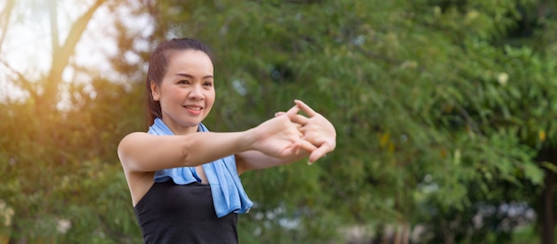 Una joven sana usa ropa deportiva haciendo estiramientos antes de hacer ejercicio al aire libre en el parque