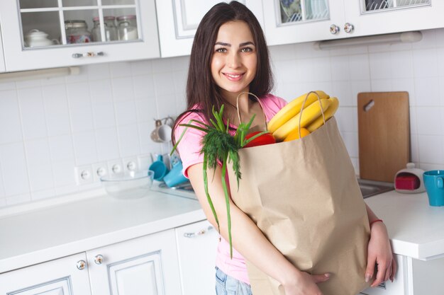 Joven sana con verduras frescas en la cocina