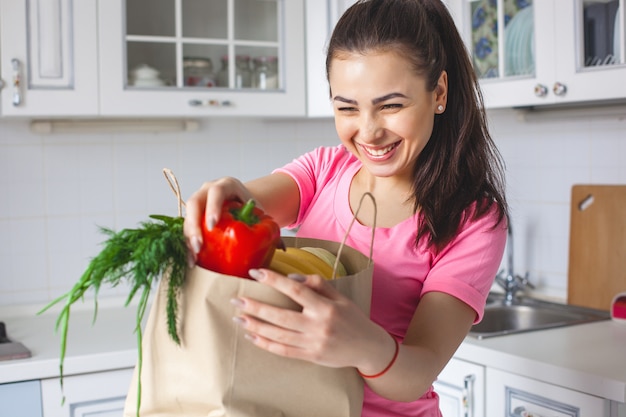 Joven sana con verduras frescas en la cocina