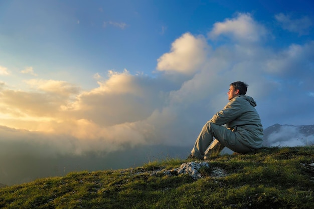 Un joven sano practica yoga en la montaña de altura temprano en la mañana y al amanecer.